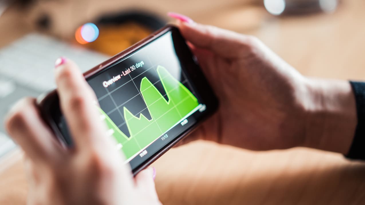 Womens hands holding a mobile phone showning a chart